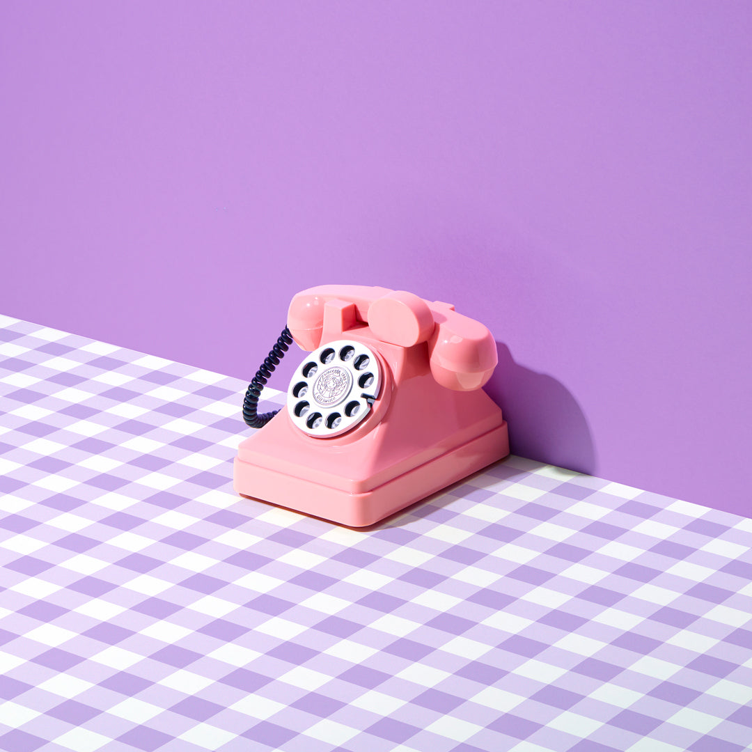 pink retro telephone on purple gingham photography backdrop
